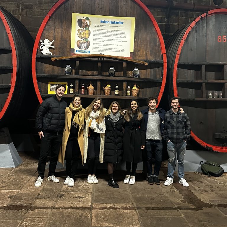 Das Plus-Ultra-Team bei einem Ausflug vor großen Weinfässern